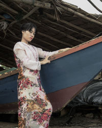 Young woman looking away while standing on wood