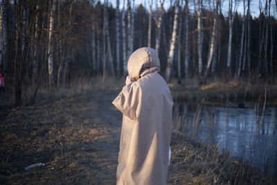 Rear view of woman standing on field