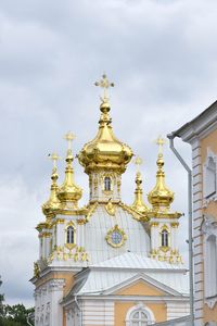 Low angle view of statue of building against cloudy sky