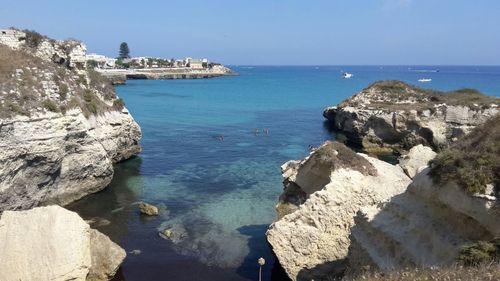 Cliffs in sea against clear sky at salento