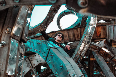 Low angle view of man on metal grate