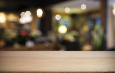 Defocused image of illuminated lights on table at restaurant