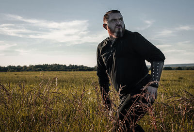 Man standing on field against sky