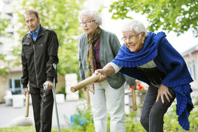 Happy senior people playing kubb game at park