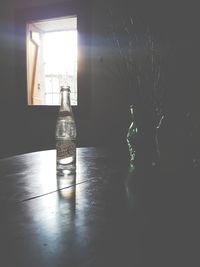 Illuminated electric lamp on table by window