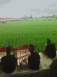 People on grassland against sky