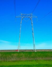 Electricity pylon on field against cloudy sky