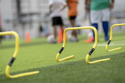 Low section of people playing soccer on field