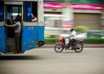 Blurred motion of man riding motorcycle on road