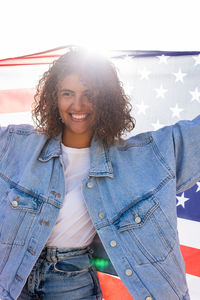 Portrait of young woman standing against sky