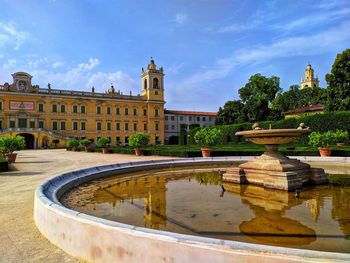 Fountain in front of building against sky