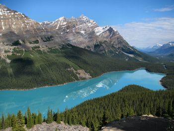 Scenic view of lake and mountains against blue sky