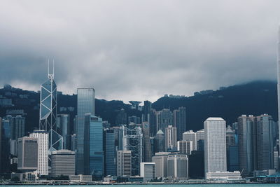 Buildings in city against cloudy sky