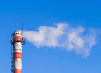 Low angle view of smoking pipe against sky