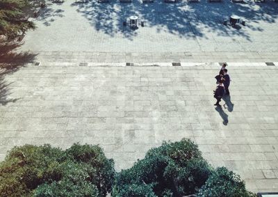 High angle view of boys in graduation gowns walking on footpath