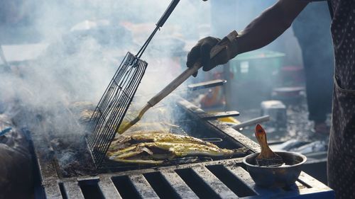 Close-up of preparing food on barbecue grill