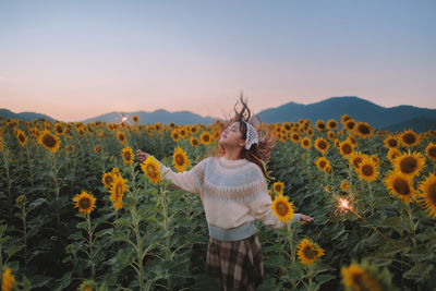 Rear view of woman standing amidst plants