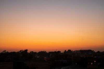 Silhouette buildings against sky during sunset