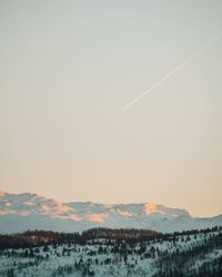 Scenic view of snowcapped mountain against sky during sunset