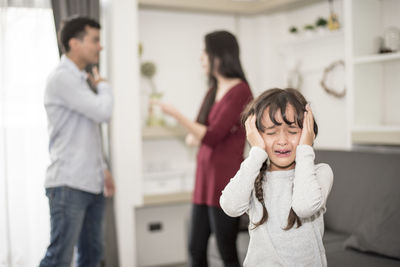 Girl crying while parents arguing at home