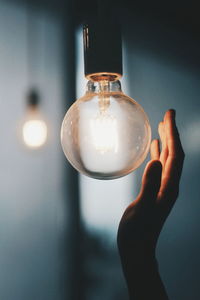 Close-up of hand holding light bulb