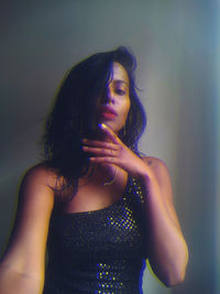 Portrait of beautiful woman standing against purple wall