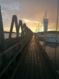 Bridge over pier against sky during sunset