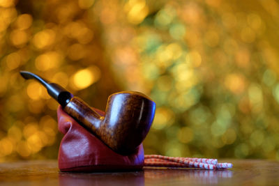 Close-up of tobacco pipe in container on table