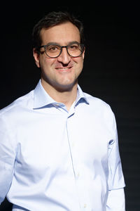 Portrait of a smiling man against black background