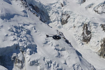 Scenic view of snowcapped mountains with rescue helicopter