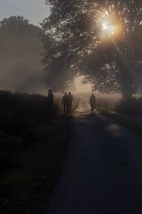 Rear view of people walking on land against sky