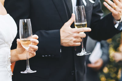 Midsection of man holding wine glass