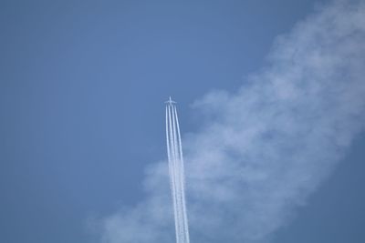 Low angle view of airplane with vapor trail flying against sky