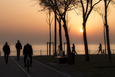 Silhouette people on beach during sunset