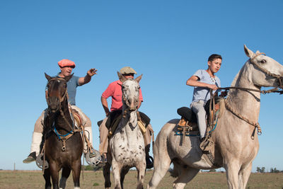 People riding horses against sky