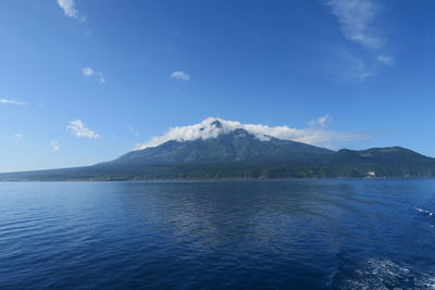 Scenic view of sea and mountains against blue sky