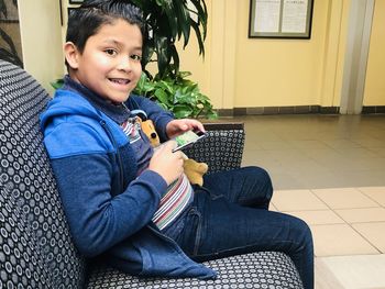 Portrait of smiling boy sitting at home