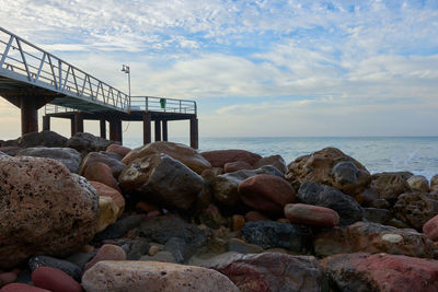 Rocks on sea shore against sky