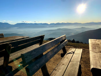 Bench on mountain against blue sky