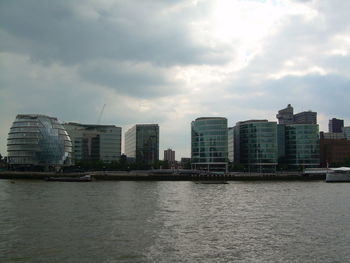 Buildings in city against cloudy sky