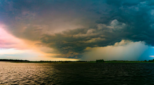 Scenic view of landscape against storm clouds