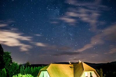 Low angle view of houses against sky at night