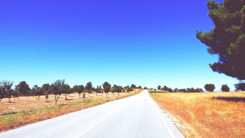 Empty road by sky in background