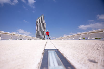 Man ski rolling on bridge against sky