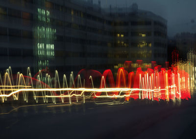 Light trails in city against sky at night