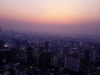 High angle view of city buildings against sky during sunset