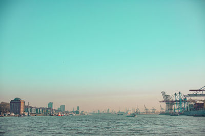 Scenic view of sea by buildings against clear sky