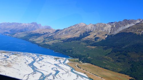 Scenic view of snowcapped mountains against blue sky