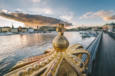 Panoramic view of bridge over river by buildings against sky