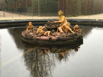 Sculpture in lake against trees